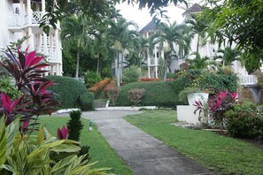 Un giardino curato con un sentiero che conduce a un edificio con balconi.