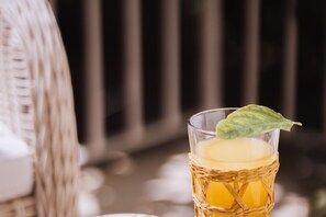 A wicker table with a glass containing a beverage and a leaf garnish. - Executive Suite with Terrace in Sorrento Center (Sorrento)
