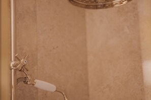Eine Dusche mit chromfarbenem Wasserhahn und flexiblem Brauseschlauch.