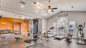 A gym with various exercise equipment, motivational wall text, and a large window. - Boulevard Stays Quiet 1BR King Suite, Pool Access, Gym (Irving)
