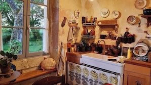 Une cuisine rustique avec une fenêtre, des étagères en bois et un poêle.