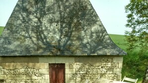 Un bâtiment en pierre avec une porte et une table recouverte d’une nappe.