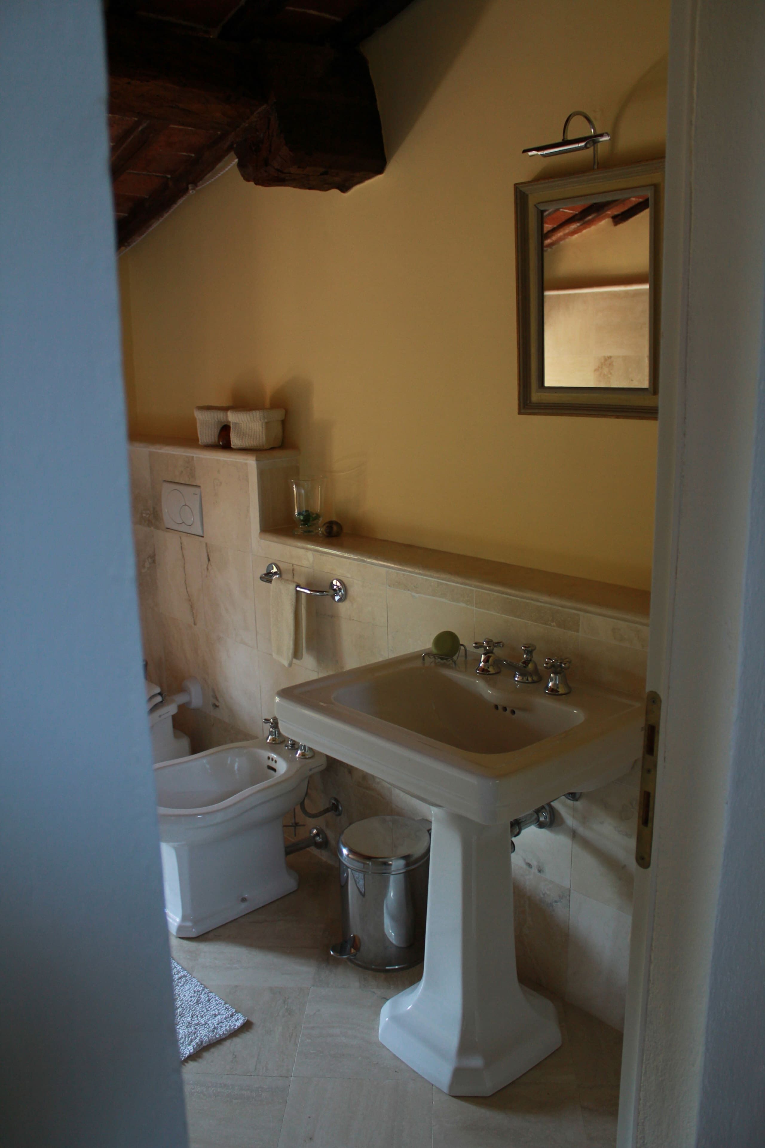 A bathroom with a pedestal sink, a toilet, and a bidet.