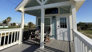 A small, single-story building with a porch, a door, and a window.