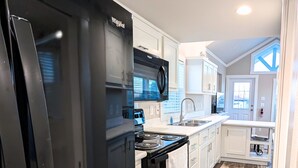 A modern kitchen with a refrigerator, stove, and sink.