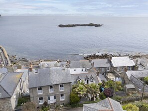 A coastal town with stone buildings, a rocky breakwater, and a view of the sea. - St Clements Cottage - Free WiFi - Outdoor kitchen and shower - Wood Burner (Mousehole)