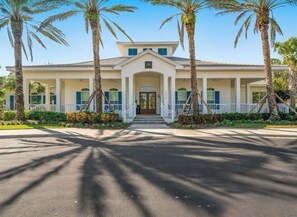 A two-story building with a symmetrical facade, a central entrance with a door, and a covered porch area. - Golf upscale resort! Pools, tennis, gym, tiki bar +. 2/2 Wellen Park Venice, Fl (Venice)