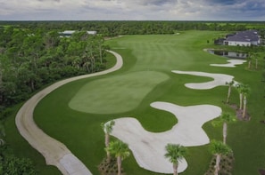 A golf course with sand bunkers, a well-maintained fairway, and a clubhouse in the background. - Golf upscale resort! Pools, tennis, gym, tiki bar +. 2/2 Wellen Park Venice, Fl (Venice)