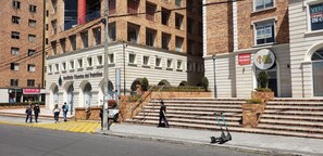 A building with a white facade, multiple windows, and a sign for 'Infinito Tennis del Delfino.' - Mini Apartment in strategic sector close to everything (Quito)