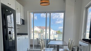 Una cocina moderna con comedor, ventanas amplias y vista al vecindario.