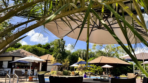 A poolside area with lounge chairs, umbrellas, and a pool. - Village with 2 Suites Facing Timeantube Lagoon - Timeantube Reserve, Praia do Forte (Açu da Torre)