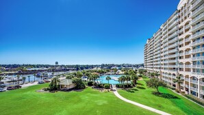 A hotel with a pool, green lawn, and a view of a marina. - Waterway View • 2300 sqft 4BR/4BA • Barefoot Golf (North Myrtle Beach)