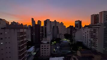 A cityscape at dusk with high-rise buildings and a sunset.