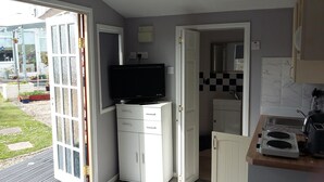 Eine kompakte Küche mit integriertem Fernseher, einer Spüle und einer kleinen Arbeitsfläche.