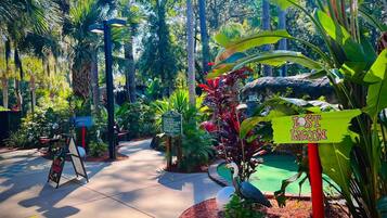 A pathway through a lush garden with signs indicating 'Paradise Falls' and 'Lost Lagoon'.