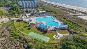 Un complexe hôtelier doté d’une piscine, de courts de tennis et offrant une vue sur la plage.