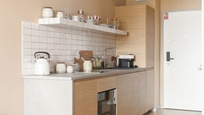 A modern kitchen with a built-in oven, a coffee maker, and a sink. - LILY APART Żurawie Premium stay (Gdańsk)