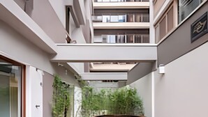 A modern interior with a wooden floor, a circular seating area, and a view of the building's exterior. - Bela Cintra (São Paulo)