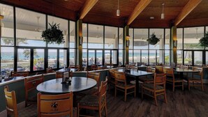 A restaurant with wooden ceilings and large windows overlooking a beach. - Fairway to Shore - your peaceful, fun and cozy beach villa! (Panama City Beach)
