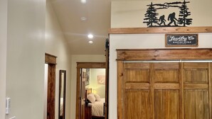 A hallway with a ceiling fan, wooden wardrobe, and a sign for a laundry service. - Little Brick House - 10min from New River Gorge Bridge (Fayetteville)