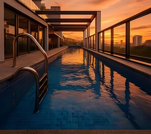 Una piscina con vistas a la ciudad al atardecer.