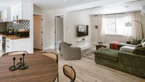 A modern living space with a dining area, kitchen, and seating area. - Modern Cabin with Fire Pit | Big Bear Ski & Hiking (Eldred)