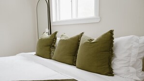 A bed with white bedding and four green pillows. - Modern Cabin with Fire Pit | Big Bear Ski & Hiking (Eldred)