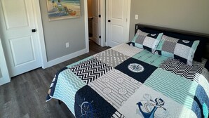 Ein Schlafzimmer mit einem Bett, einem Bild und einer Tür.