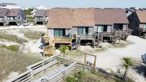 Ein Strandgrundstück mit Holzbauten, einem Sandstrand und einer Holzpromenade.