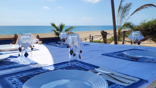 Ein Esstisch mit Blick auf Strand und Meer.