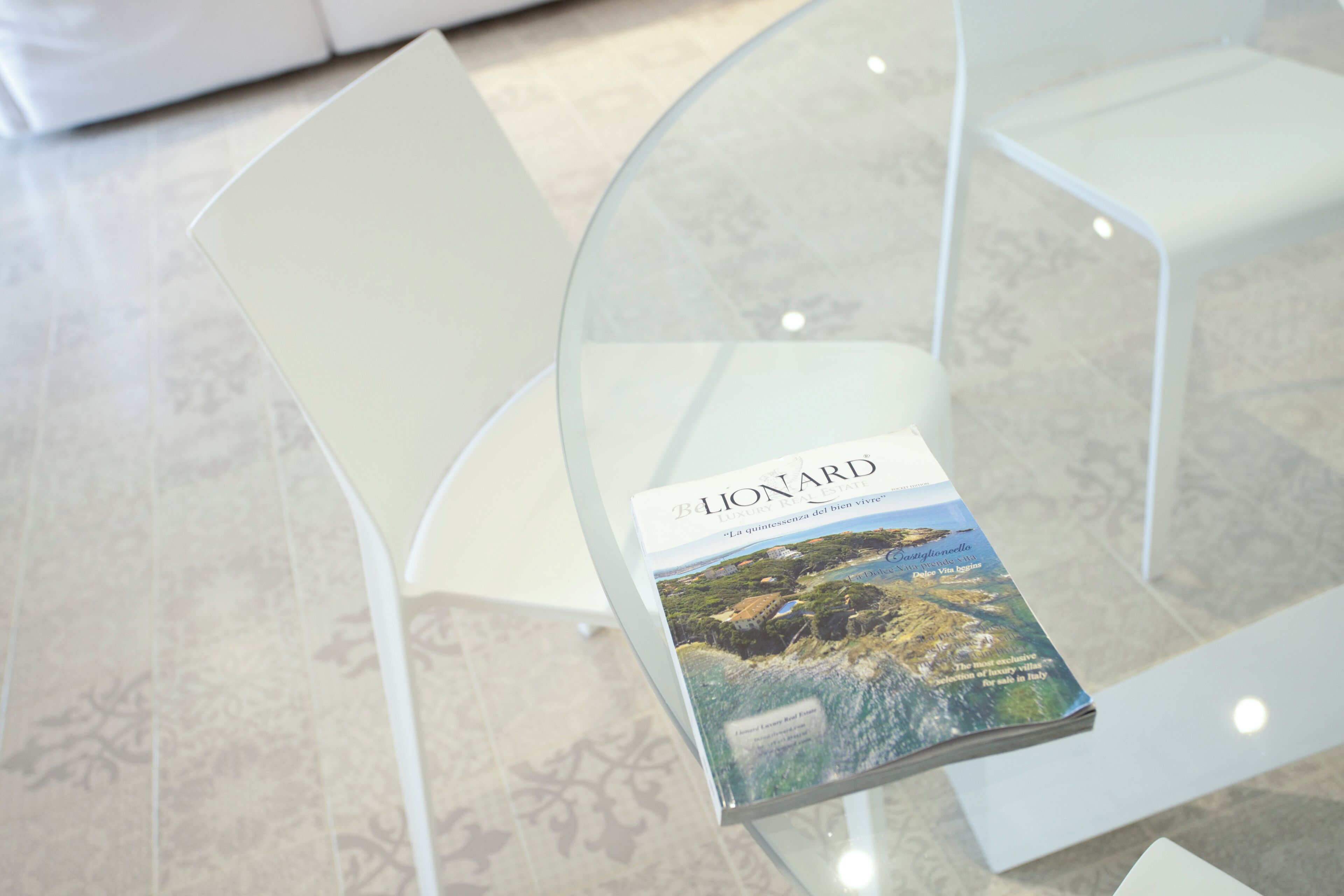 A glass table with a brochure titled 'LIONARD' on it.