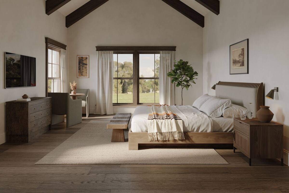 A bedroom with a large bed, wooden beams, a desk, and a view of the outdoors.