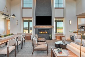 A spacious living room with a fireplace, seating area, and large windows. - Tributer Resort (Mineral)