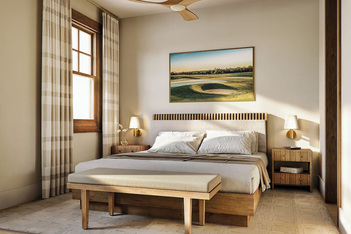 A bedroom with a bed, bedside tables, a bench, a ceiling fan, and a painting on the wall.