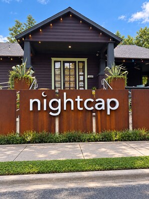 Un bâtiment avec une enseigne indiquant « bar nocturne » à l’entrée.