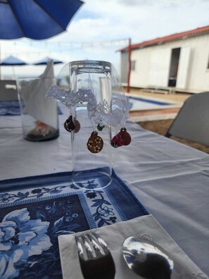 Une table sur laquelle se trouve un vase en verre transparent contenant des objets décoratifs, un parapluie bleu et une nappe à motifs floraux.