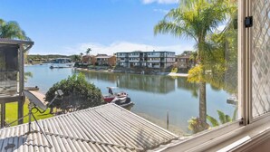 A residential area with a view of a calm water body, houses, and a boat dock. - Family Friendly 2 Bed Flat with Balcony (Mooloolaba)