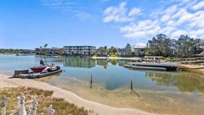 A marina with boats, a sandy beach, and buildings in the background. - Family Friendly 2 Bed Flat with Balcony (Mooloolaba)