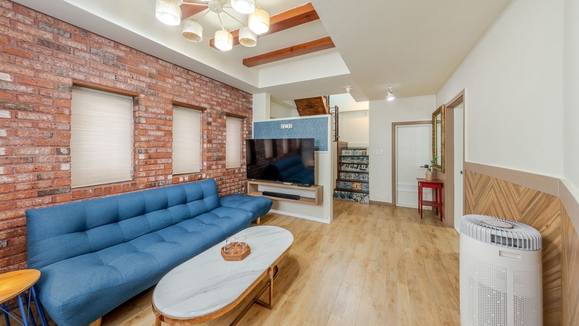 Una sala de estar con un sofá azul, un televisor y una chimenea.