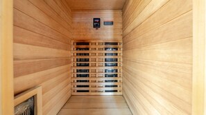 Uma sauna com paredes de madeira e um banco central.