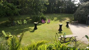 A well-maintained garden with green lawn, outdoor seating, and a patio area. - Latitude Ouest Hotel Restaurant Spa (Locronan)