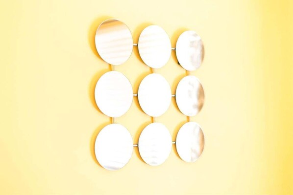 Un mur orné de miroirs ronds disposés selon un motif en réseau.