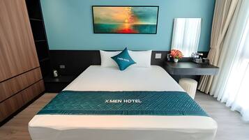 A hotel room with a bed, a nightstand, a desk, a chair, a mirror, and a painting on the wall.