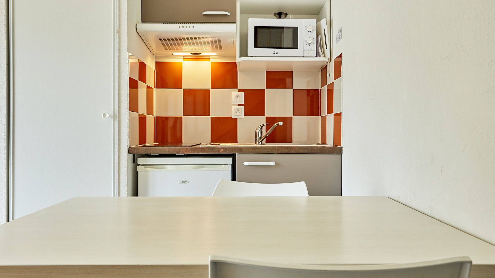 A compact kitchen with a microwave, stove, and dishwasher.