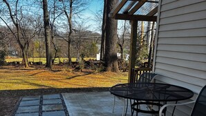 Un patio con un camino de piedra, mobiliario exterior y vistas del paisaje circundante.