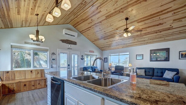 A kitchen with a granite countertop, stainless steel sink, and wooden ceiling. - Canal Fishing Retreat - Dock, Sky Deck, Golf Cart (Rockport)