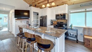 A kitchen with a large island, stainless steel appliances, and a wooden ceiling. - Canal Fishing Retreat - Dock, Sky Deck, Golf Cart (Rockport)