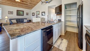 A kitchen with a granite countertop, white cabinetry, a dishwasher, and a wooden ceiling. - Canal Fishing Retreat - Dock, Sky Deck, Golf Cart (Rockport)