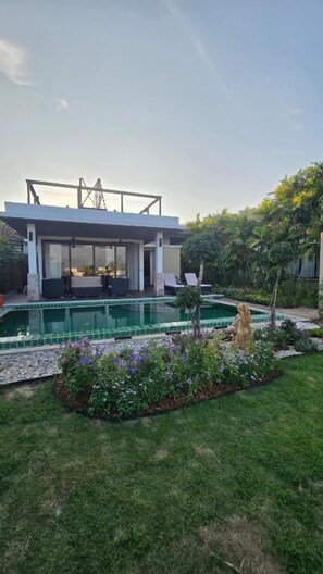 A modern house with a pool, a covered outdoor seating area, and a well-maintained garden. - Seaview Spirit Private Pool Villa (Hua Hin)