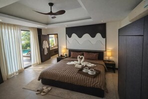 A modern hotel room with a large bed, a ceiling fan, a view of the outdoors, and a wall-mounted artwork. - Seaview Spirit Private Pool Villa (Hua Hin)